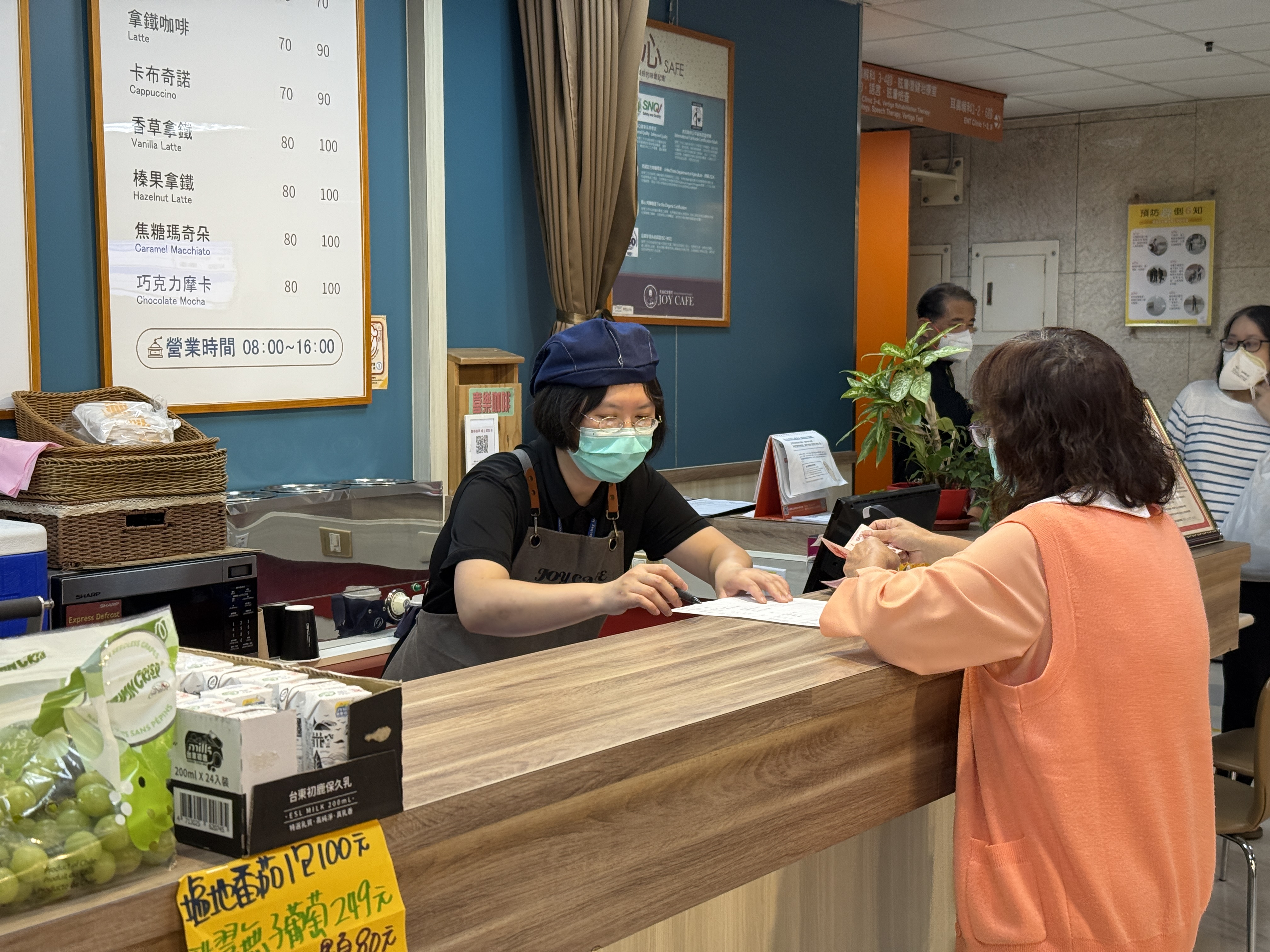 圖1顧客在櫃檯前，準備點餐，員工熟練操作點餐機台