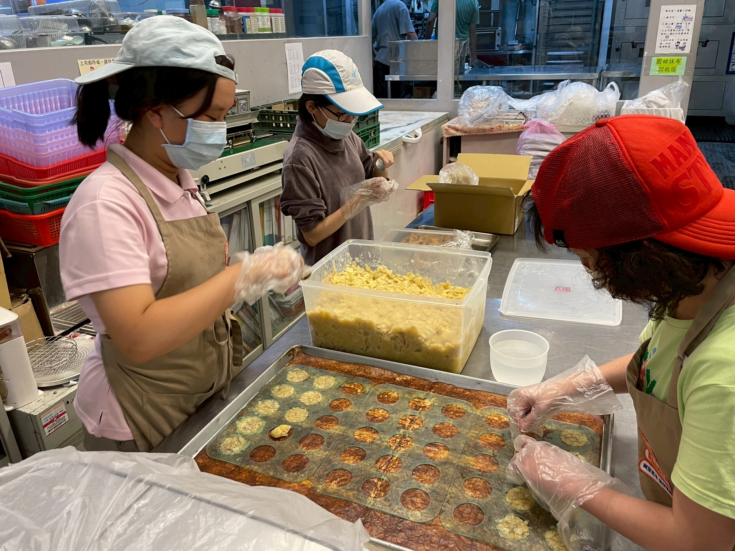 員工用雙手一個個仔細捏,專注製作杏仁餅,要給顧客最用心的餅乾。(圖/糕菲庇護工場提供)